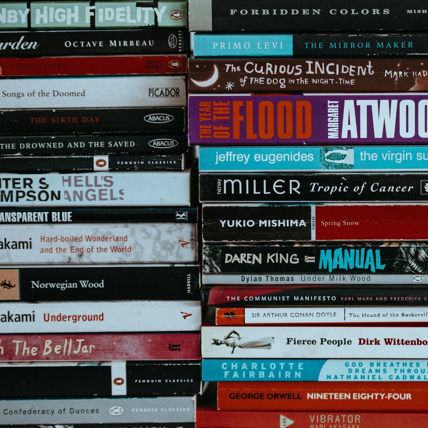 Stack of books with various titles and authors on a black background