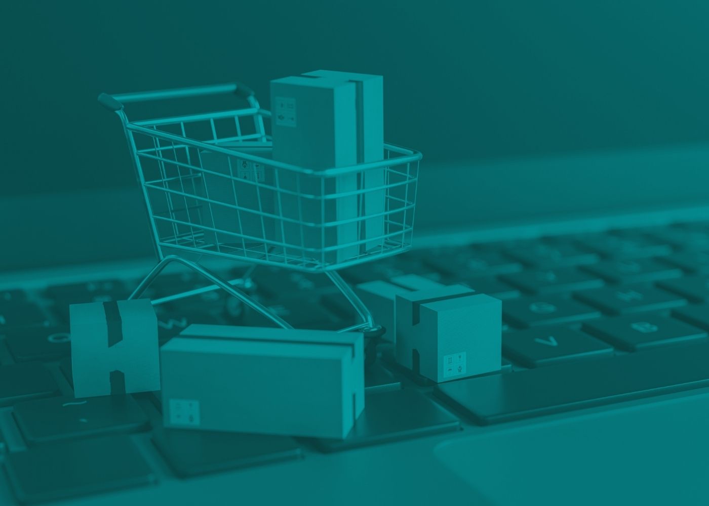 Shopping cart and boxes on a keyboard with a teal filter