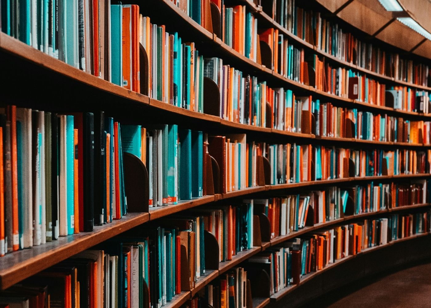 A curved bookshelf filled with titles in a professional setting