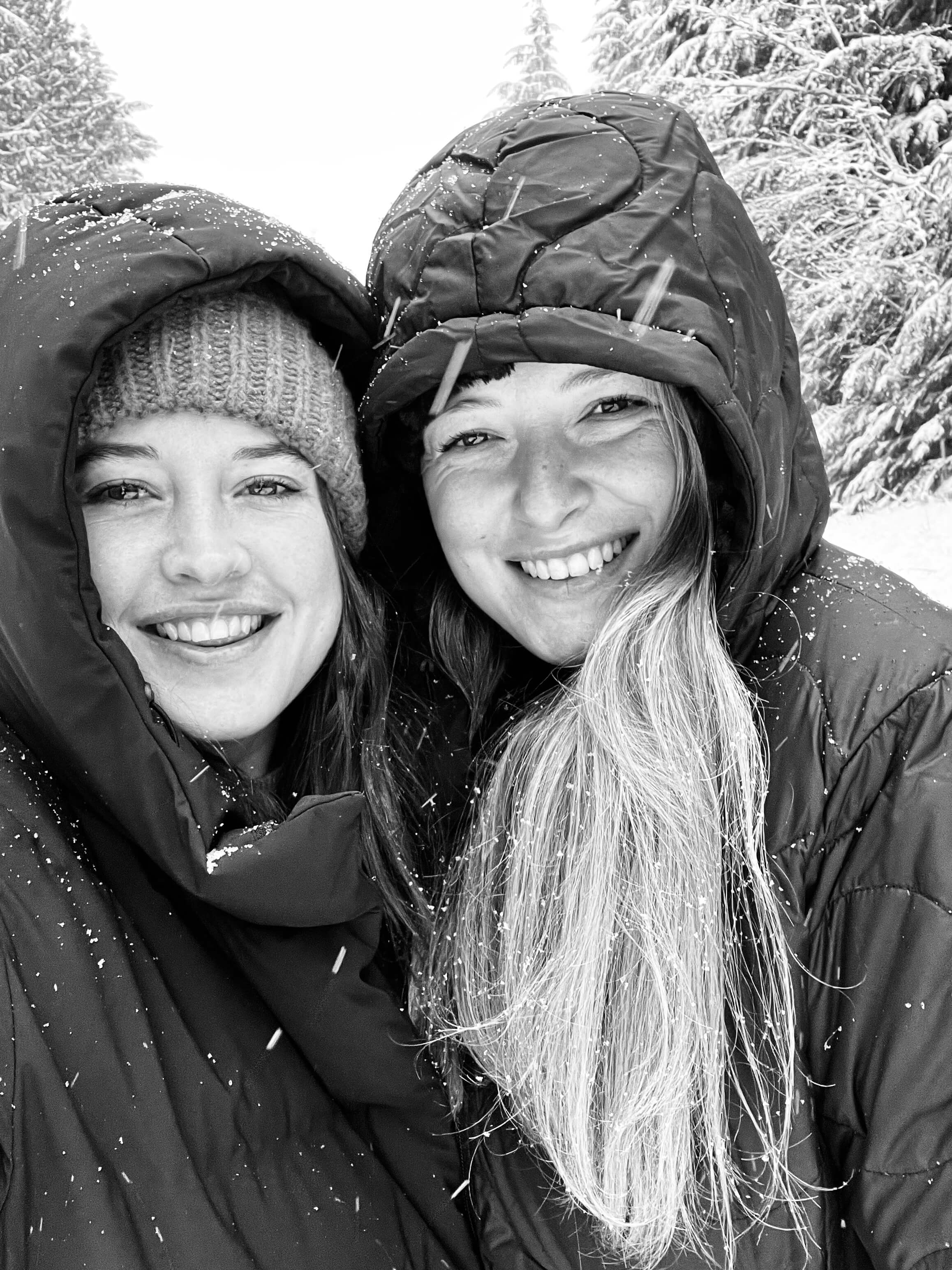 Two people smiling outdoors in a snowy landscape