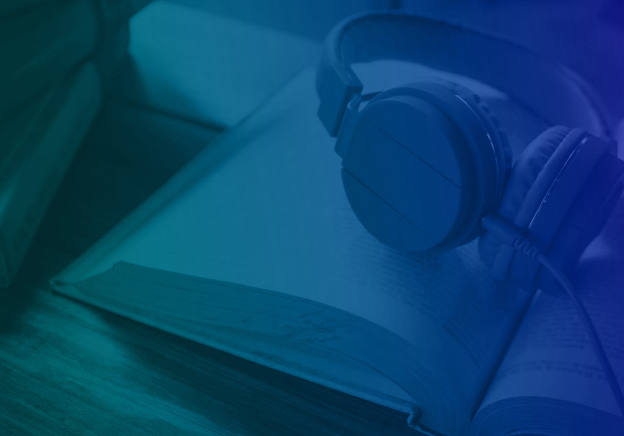 Blue-toned close-up of over-ear headphones resting on an open book.