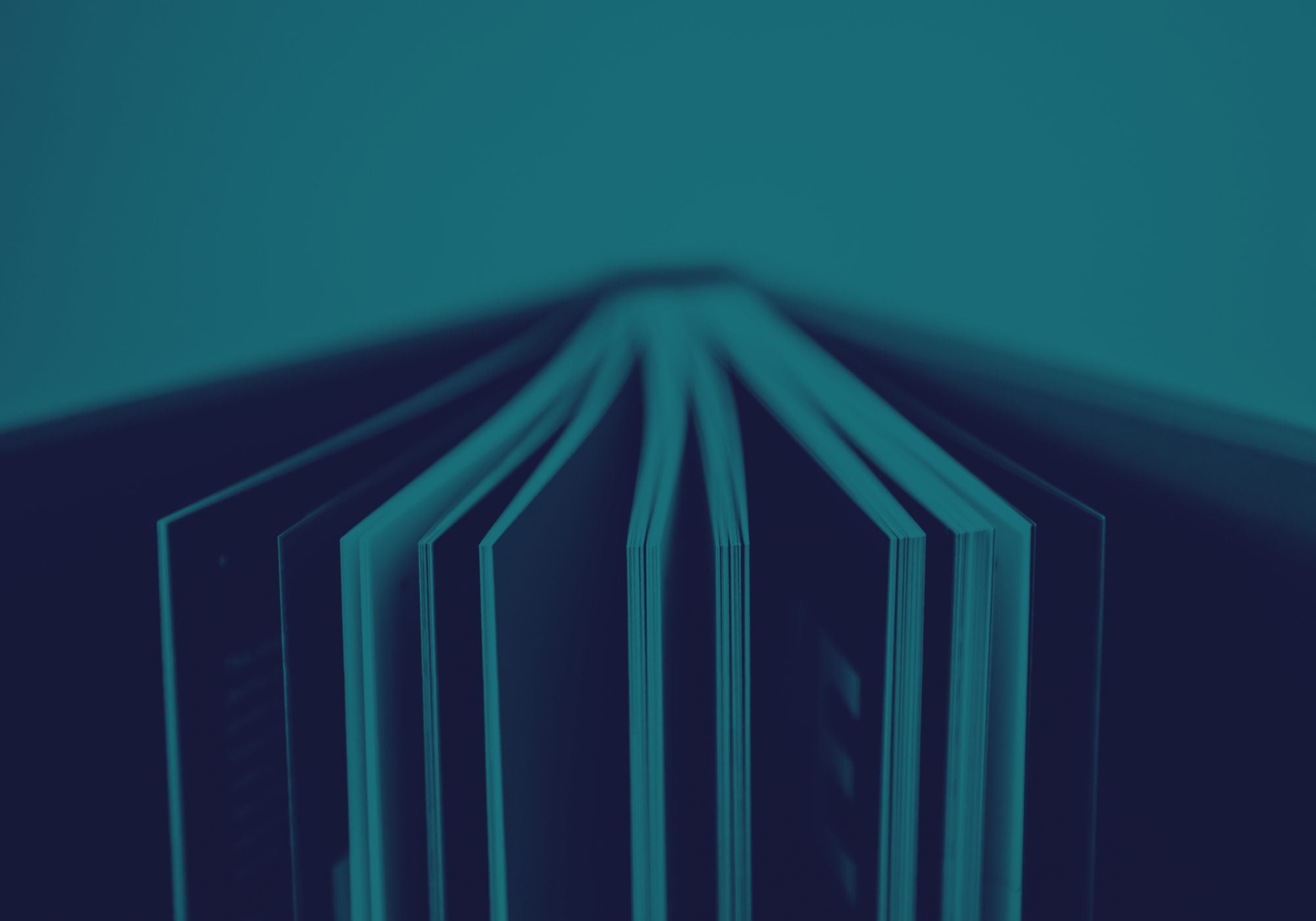 Close-up of a book with a teal color overlay on a dark background