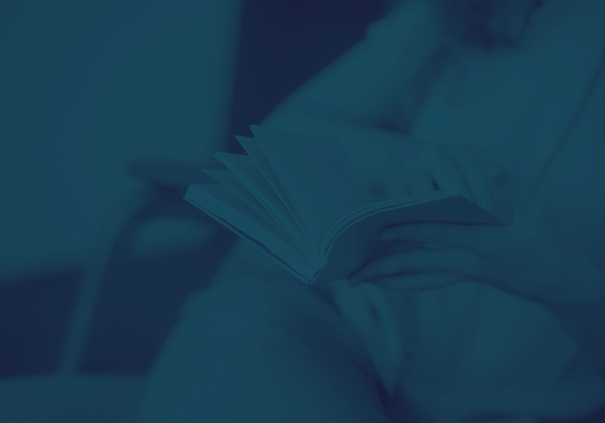 Burred image of a person reading a book with light clothing  with a blue filter